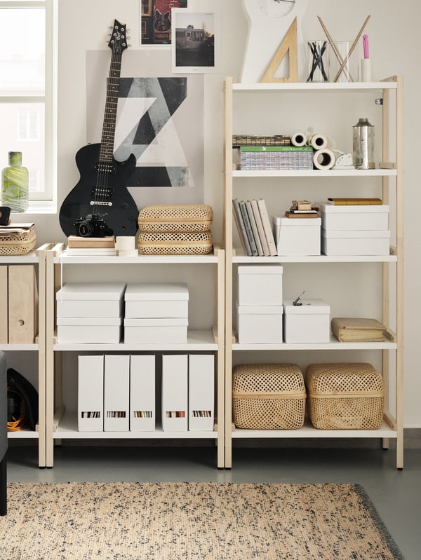 An EKENABBEN open shelving unit combination against a white wall holding storage boxes and baskets and an electric guitar.