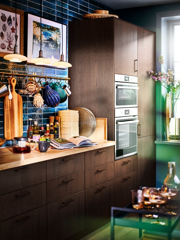 A SINARP kitchen with a stainless steel ANRÄTTA forced air oven and microwave, with pendant lamps above a worktop.