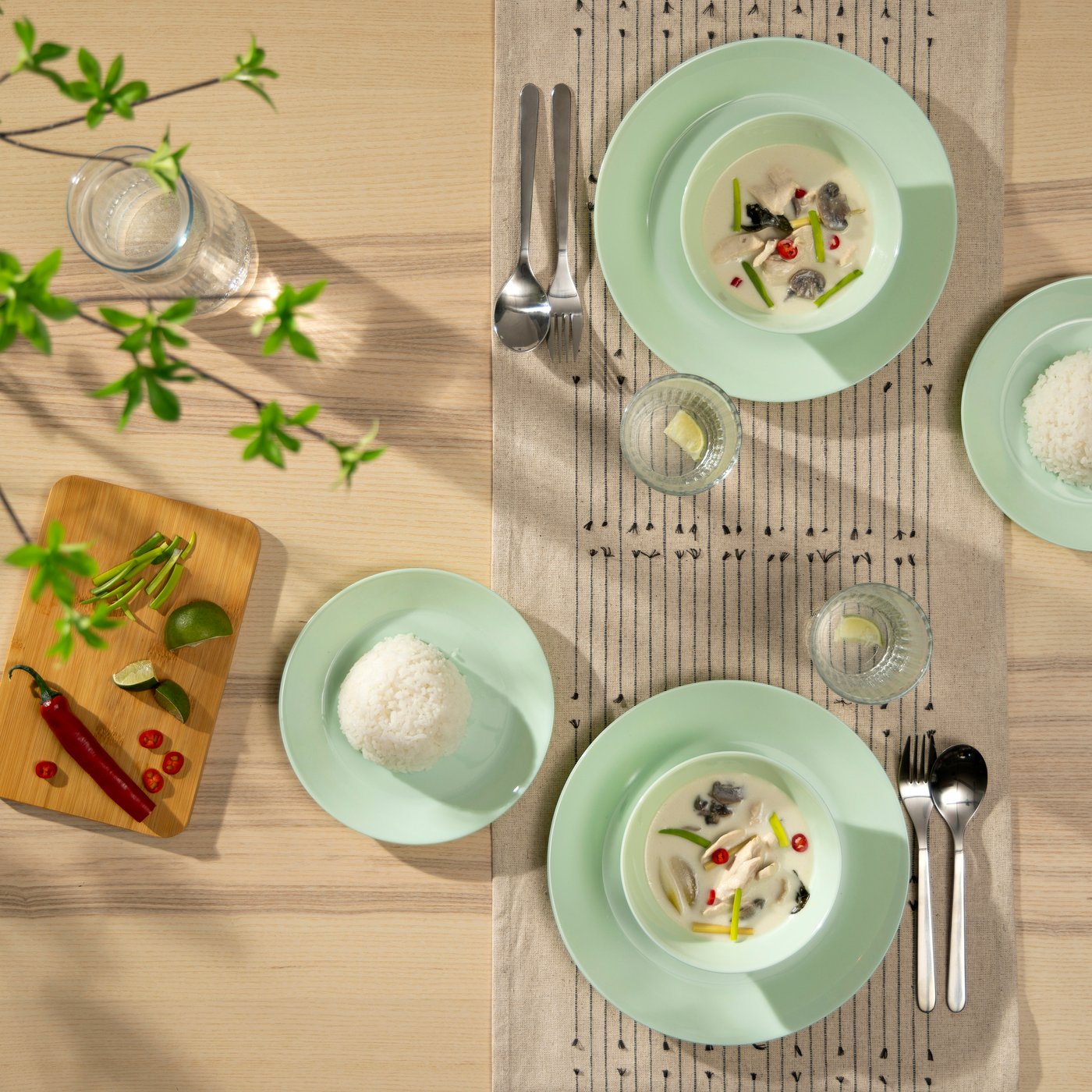 Ein Tisch ist gedeckt mit OFTAST Essgeschirr in hellgrün