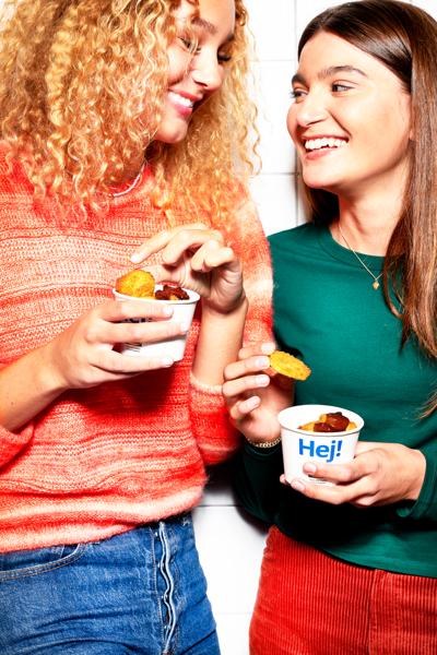 Zwei Personen stehen nebeneinander und halten kleine Becher mit Plant-Nuggets in der Hand.