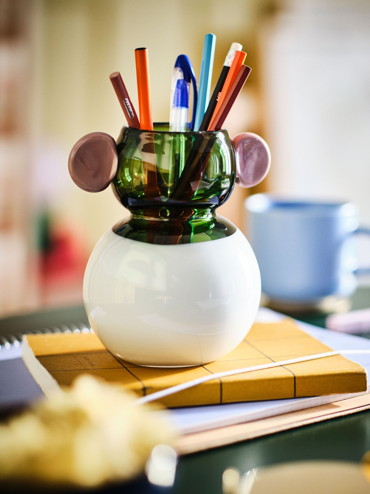 A glass/white/green pink IKEA PS 2026 vase in the home office