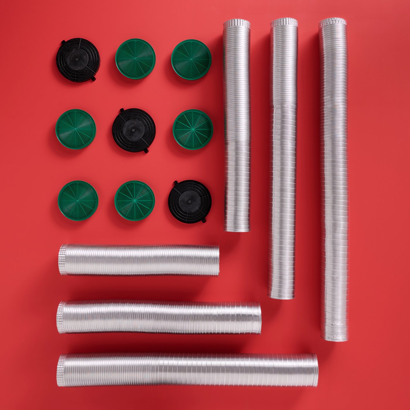 NYTTIG flexible pipes of different lengths and NYTTIG charcoal filters are placed next to each other on a red surface.