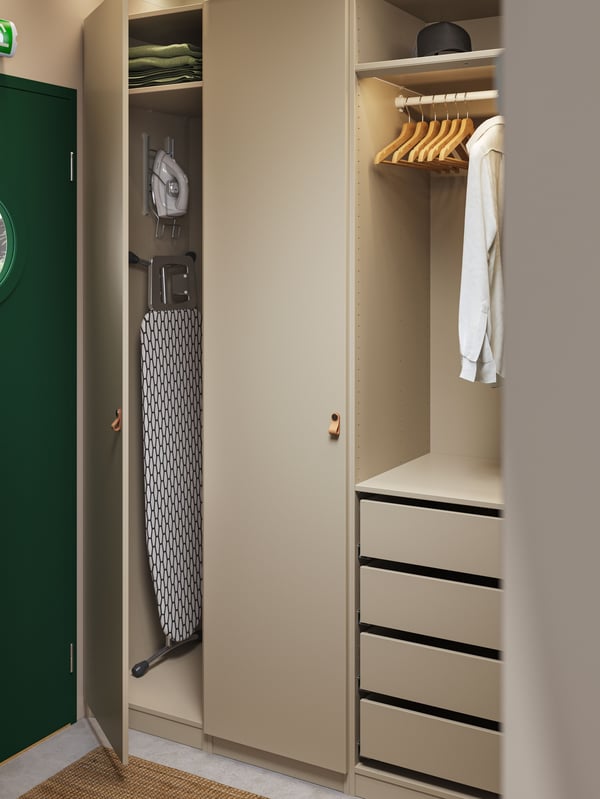 A hotel room with a PAX wardrobe with drawers, hangers, shelves and storage space for an iron and an ironing board.