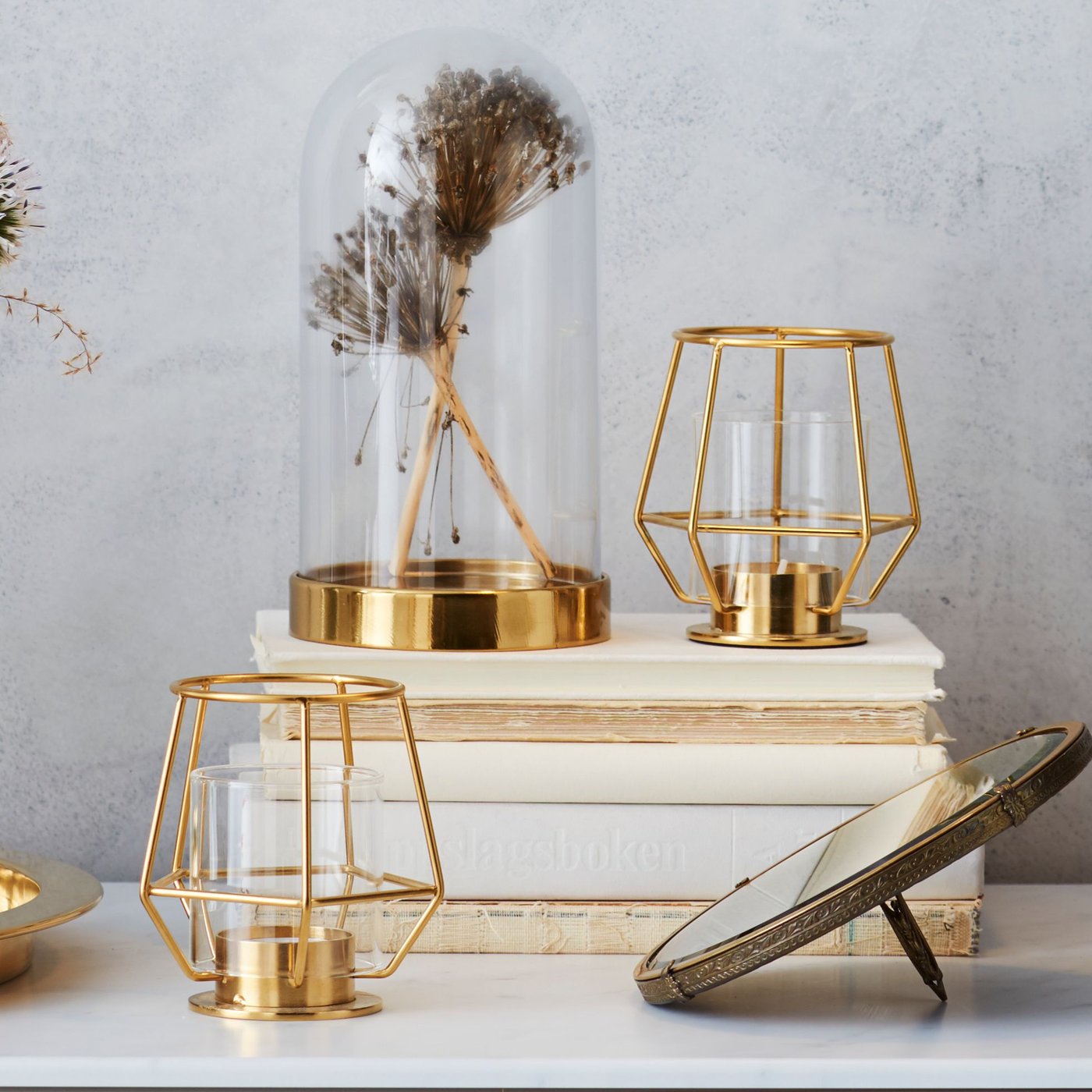 A gold-colour PÄRLBAND tealight holder in the living room