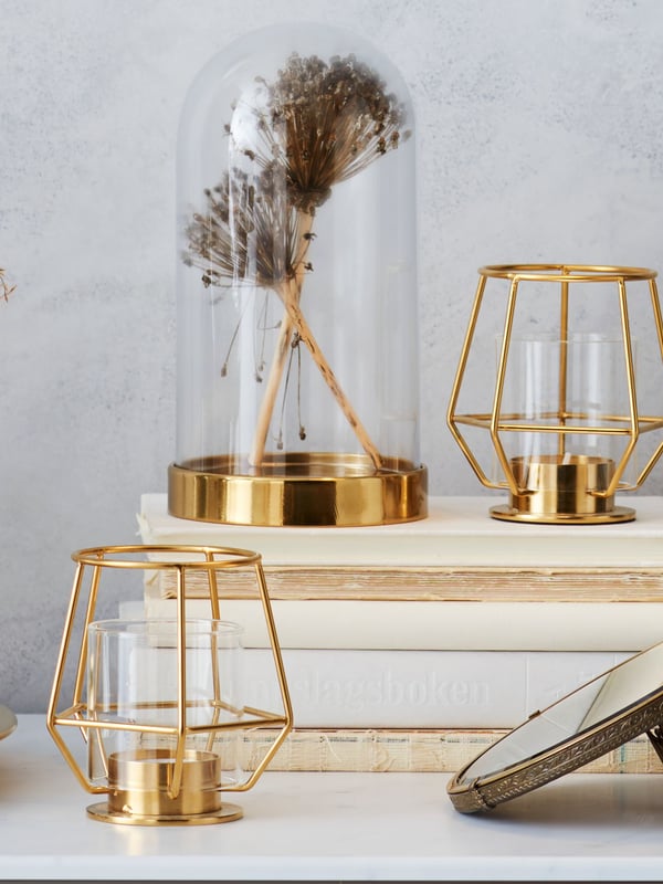 A gold-colour PÄRLBAND tealight holder in the living room