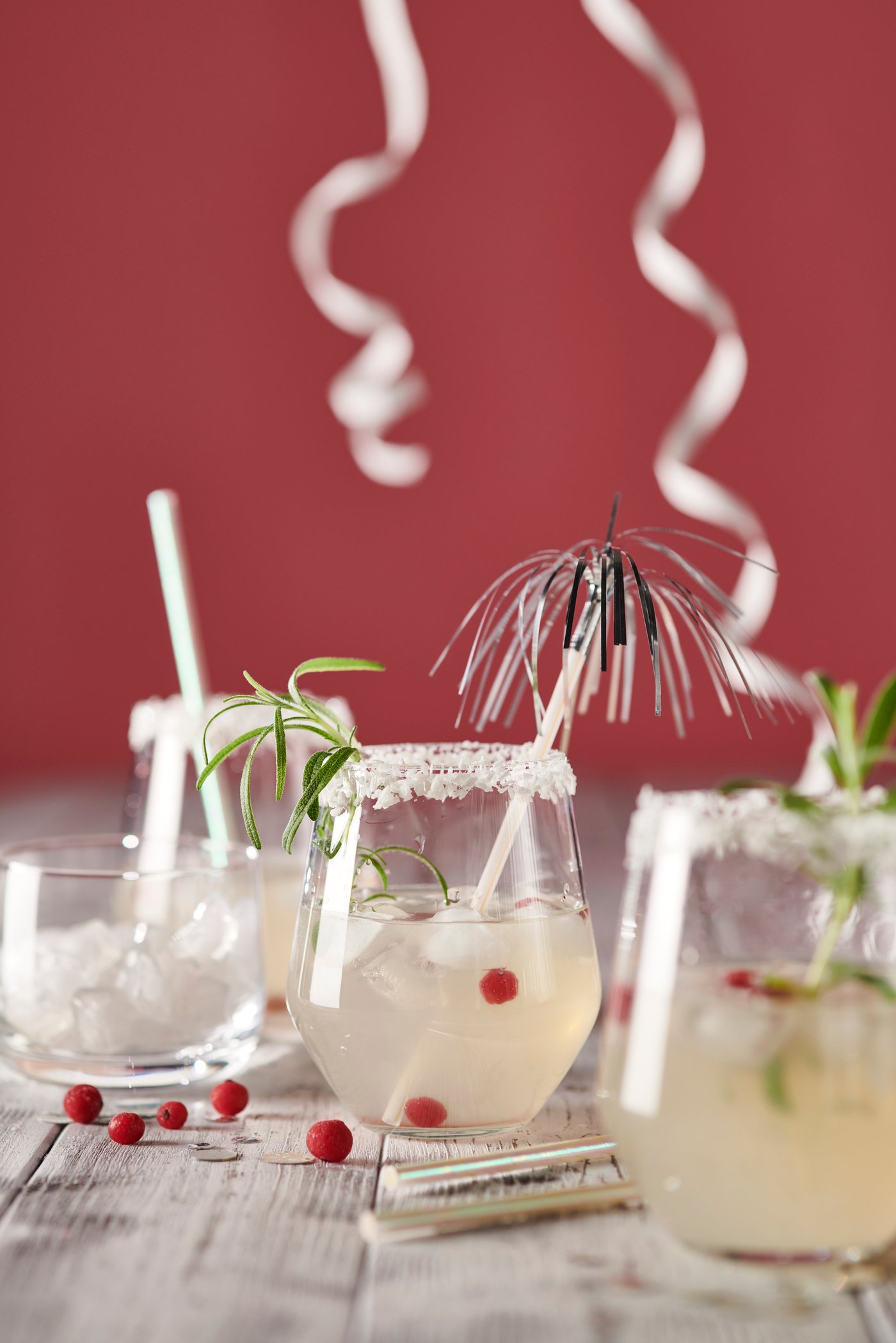 Tre STORSINT glas står på et bord med festlige drinks i, en sukkerkant og paraply i