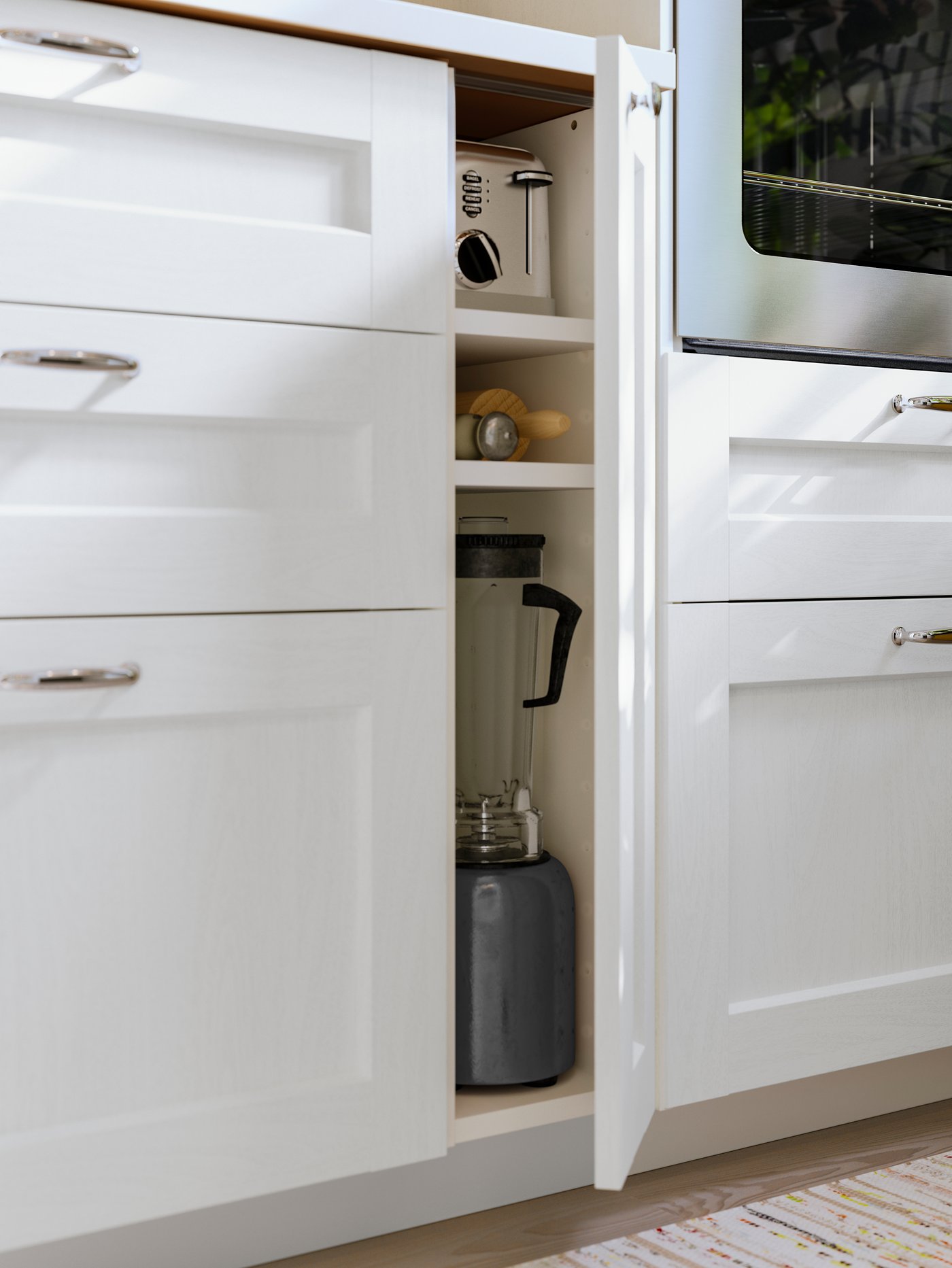 A narrow cabinet with a white ENKÖPING front and an ENERYDA knob has the door slightly ajar and there is kitchenware inside.
