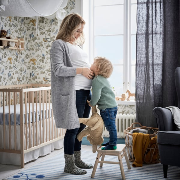 cameretta da bambini con un letto SINGLAR e una mamma con il suo bambino che è salito sullo sgabello VILTO per abbracciarla e tiene in mano il peluche GOSIG GOLDEN