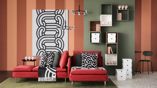 A living room styled with the SÖTRÖNN collection, featuring black and white pillowcases with a fun print, throws, and a large print on the wall as wall decoration