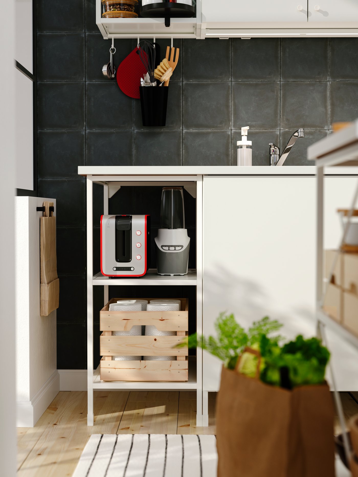 Zona de la cocina con una base blanca con estantes apoyados en patas, una encimera, una caja, una barra con ganchos y una alfombra.