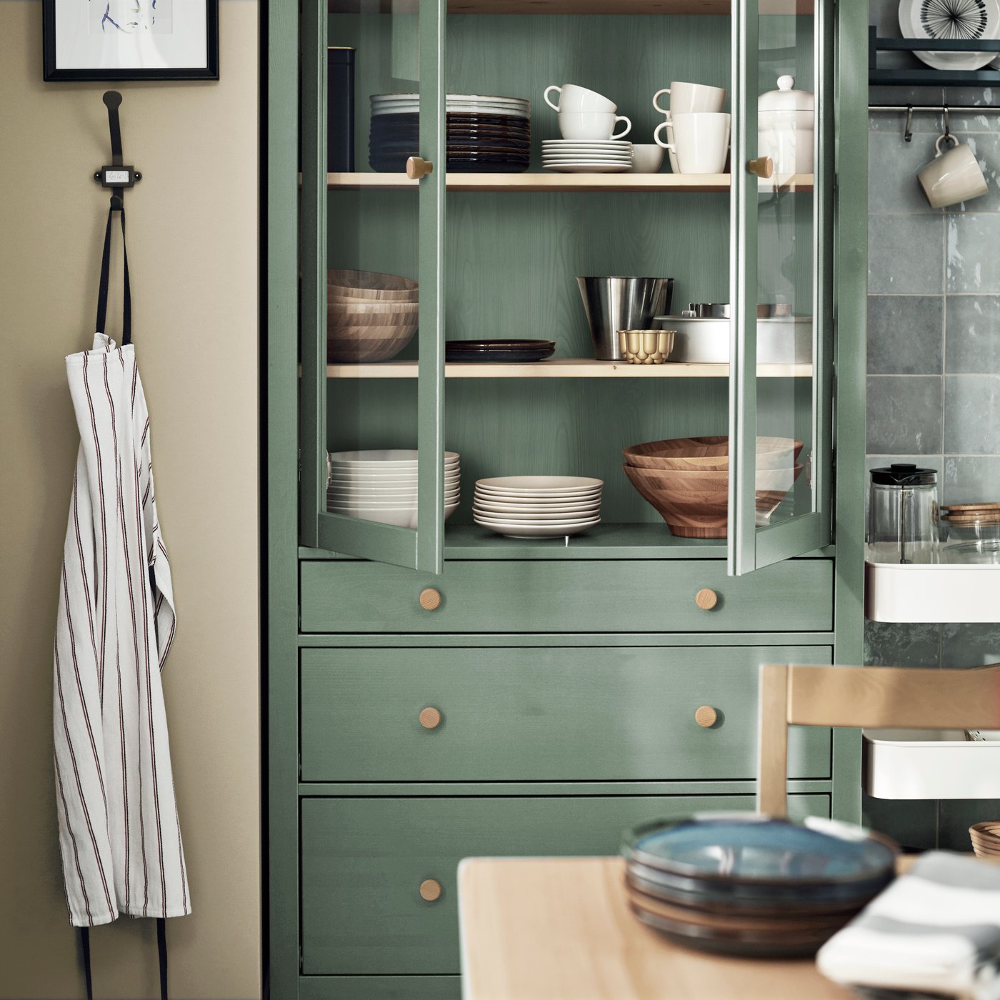 A grey-green/light brown stained HEMNES glass-door cabinet with 3 drawers
