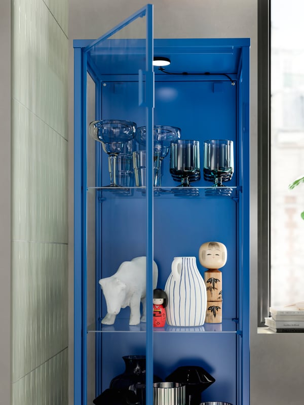 Vitrina RUDSTA em azul junto a janela luminosa numa sala.
