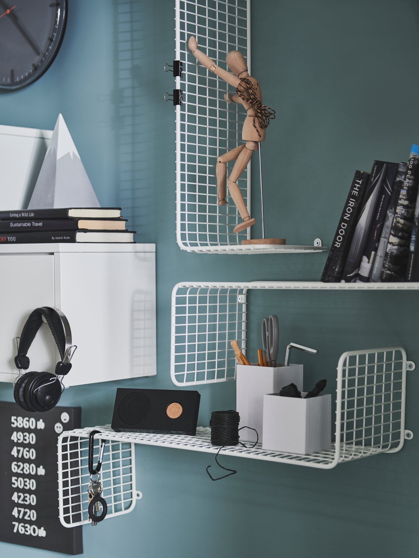 A white shelf with a bevelled edge and black brackets above a door frame, with boxes and books on it.