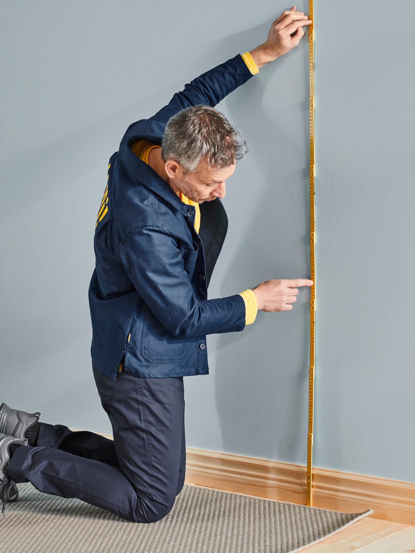 Man measuring wall