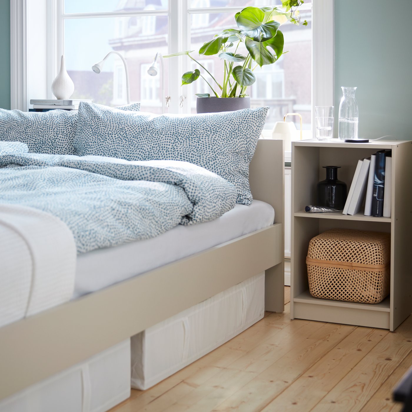 A white NÄVLINGE LED work lamp in the bedroom