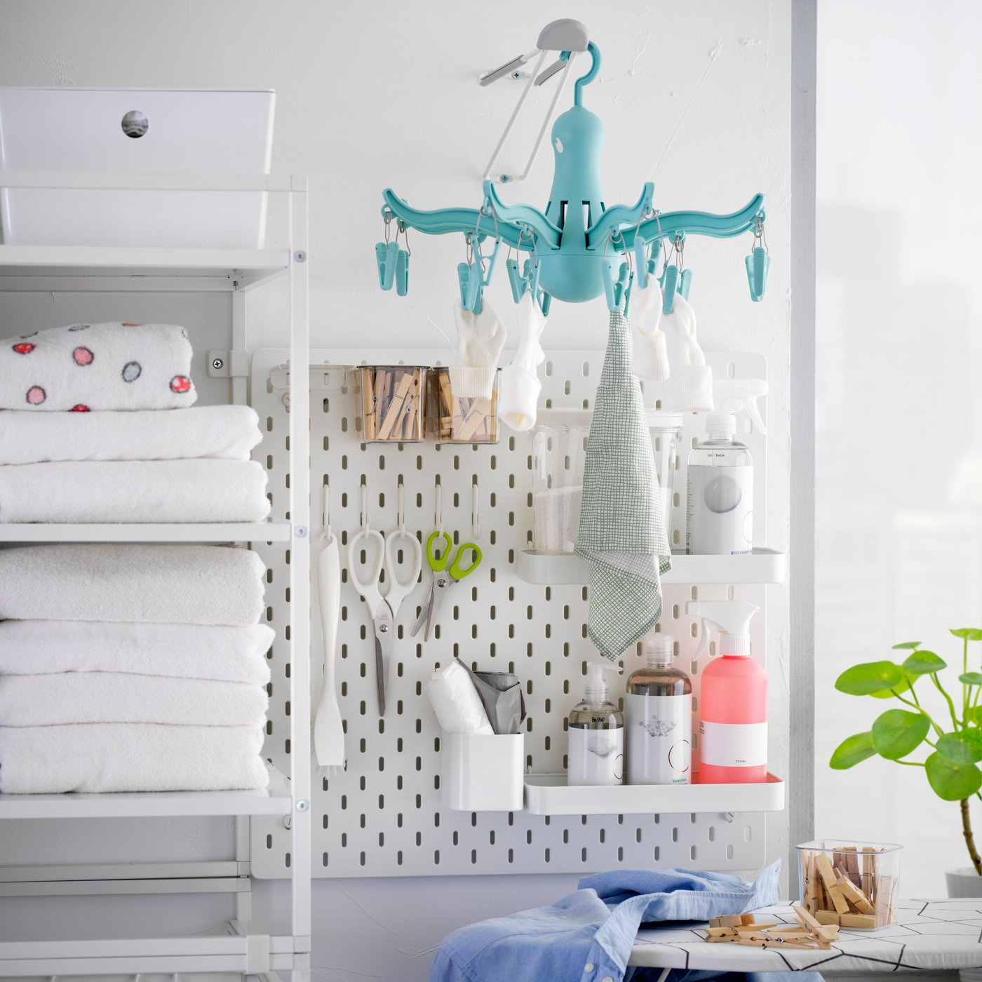 A turquoise PRESSA hanging dryer 16 clothes pegs in the laundry room