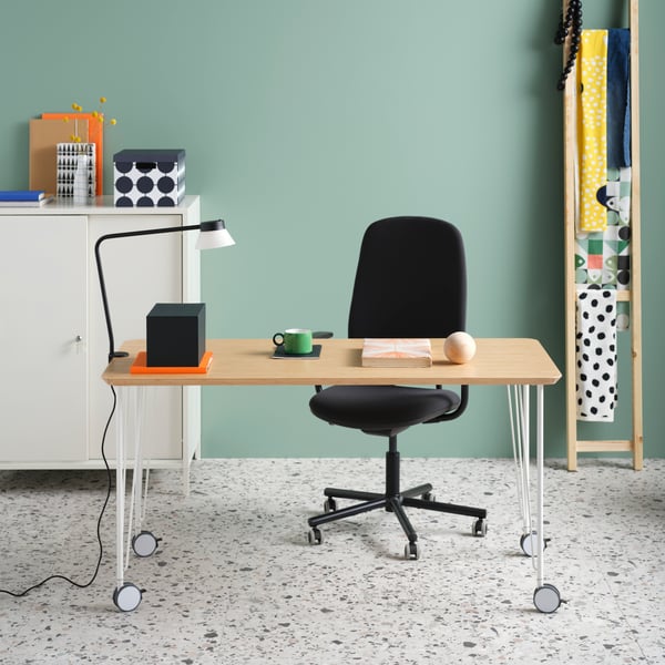 A bamboo ANFALLARE tabletop on KRILLE legs with castors, a SMÖRKULL office chair, and a TROTTEN cabinet with sliding doors.