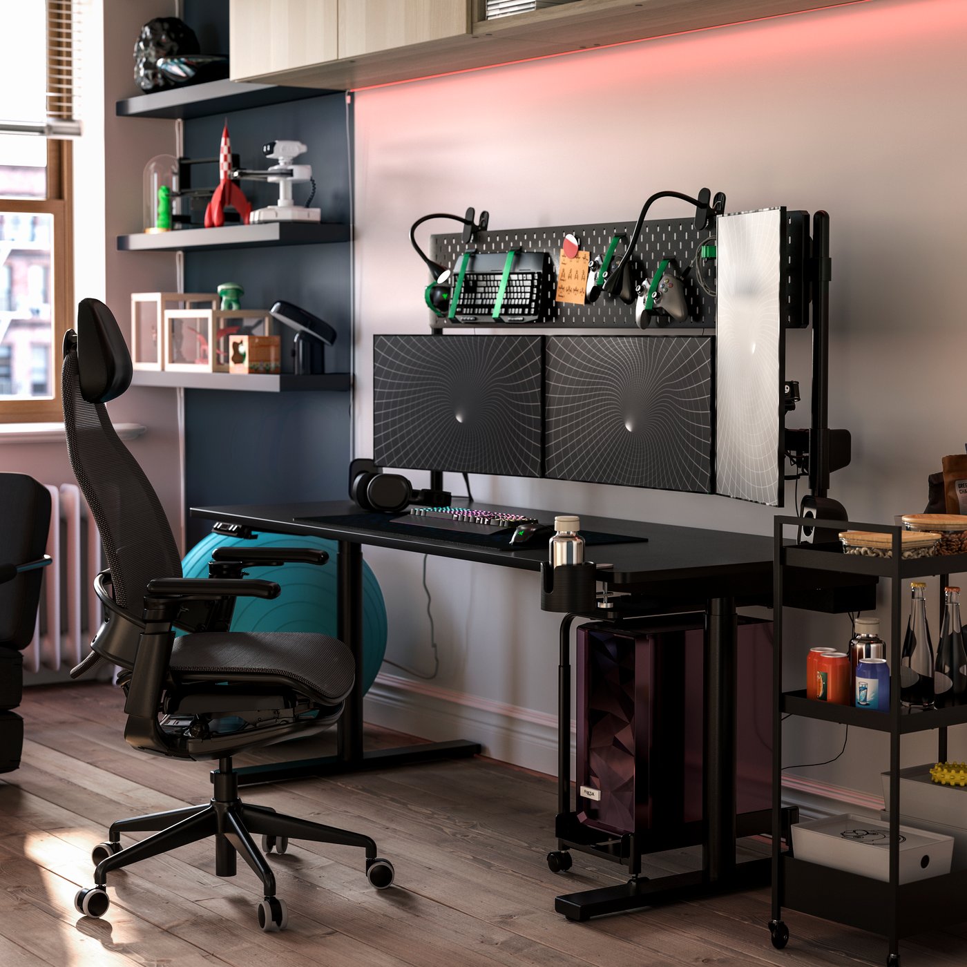 Ein schwarzer MÅLOMRÅDE Sitz-/Steh-Gaming-Tisch steht in einem stilvollen Raum mit Regalen, einem Gaming-Stuhl und Gaming-Ausrüstung.