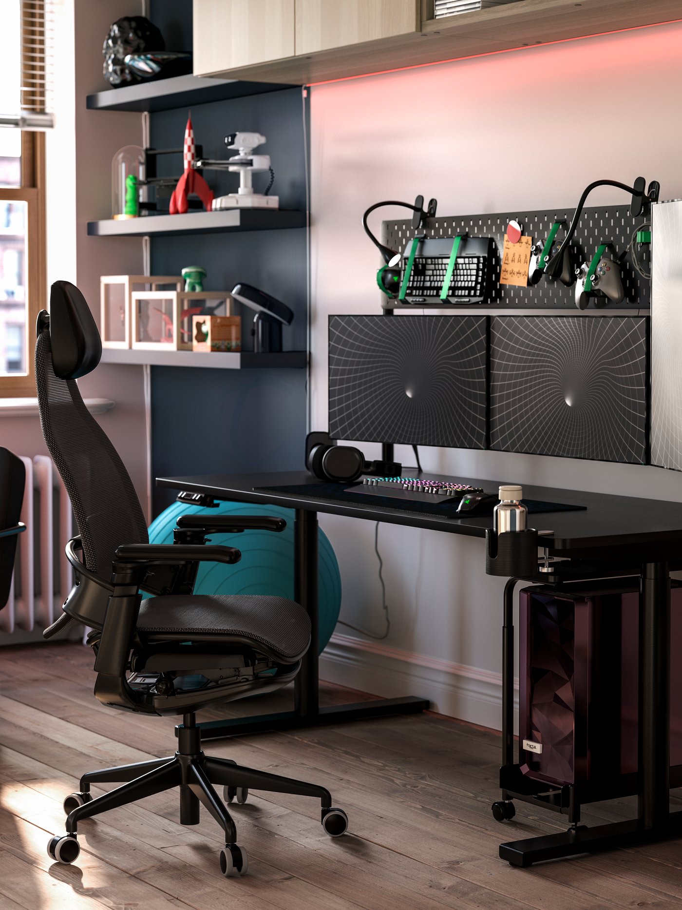 Ett svart MÅLOMRÅDE gamingbord med sitt-/ståfunktion står i ett stilfullt rum med hyllor, en gamingstol och gamingutrustning.