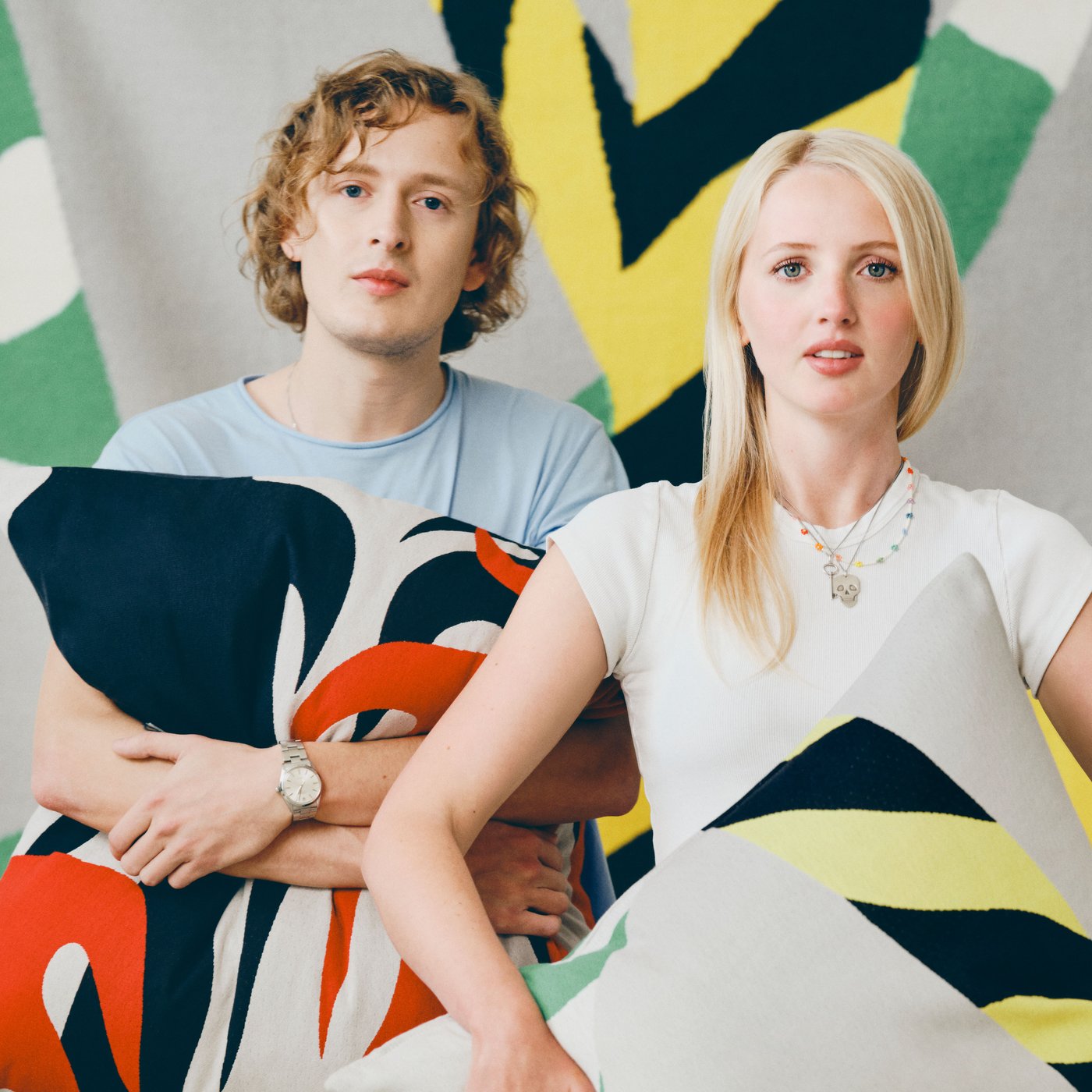 Designers Igor and Ingrid holding colourful cushions designed for the IKEA KONSTRUNDA art collection.