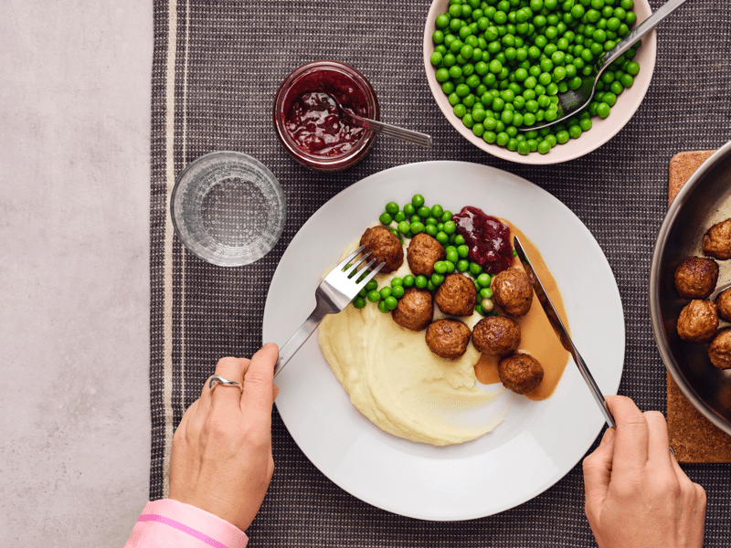 Danie klopsiki z sosem pieczeniowym, zielonym groszkiem i puree ziemniaczanym.