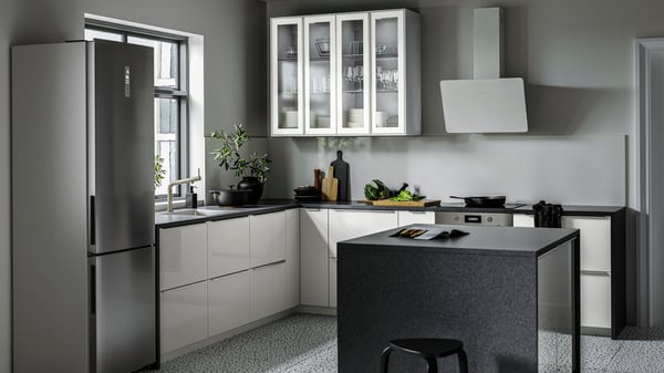 A light grey high-gloss RINGHULT kitchen with an island, a black worktop and metal, slimline handles.