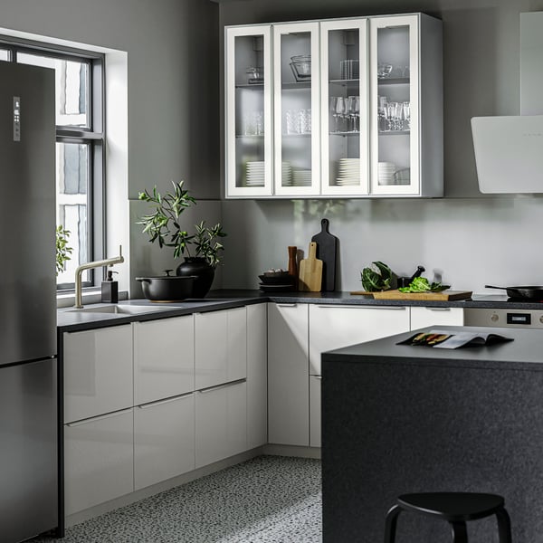 Cozinha RINGHULT em cinzento claro brilhante com bancada em branco e puxadores em metal elegantes.