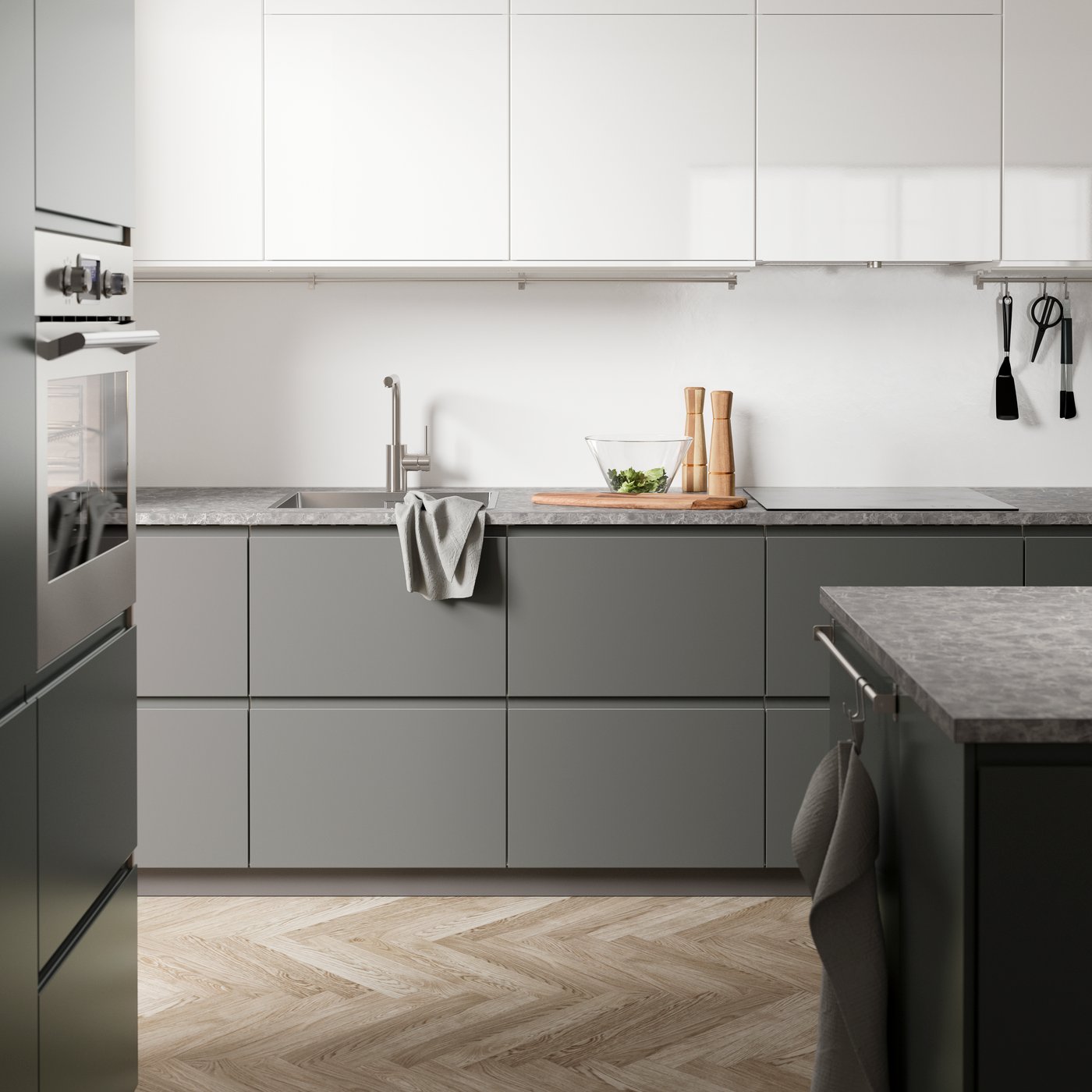 A dark grey kitchen with dark grey VOXTORP kitchen fronts, a dark grey stone-effect worktop and an island.
