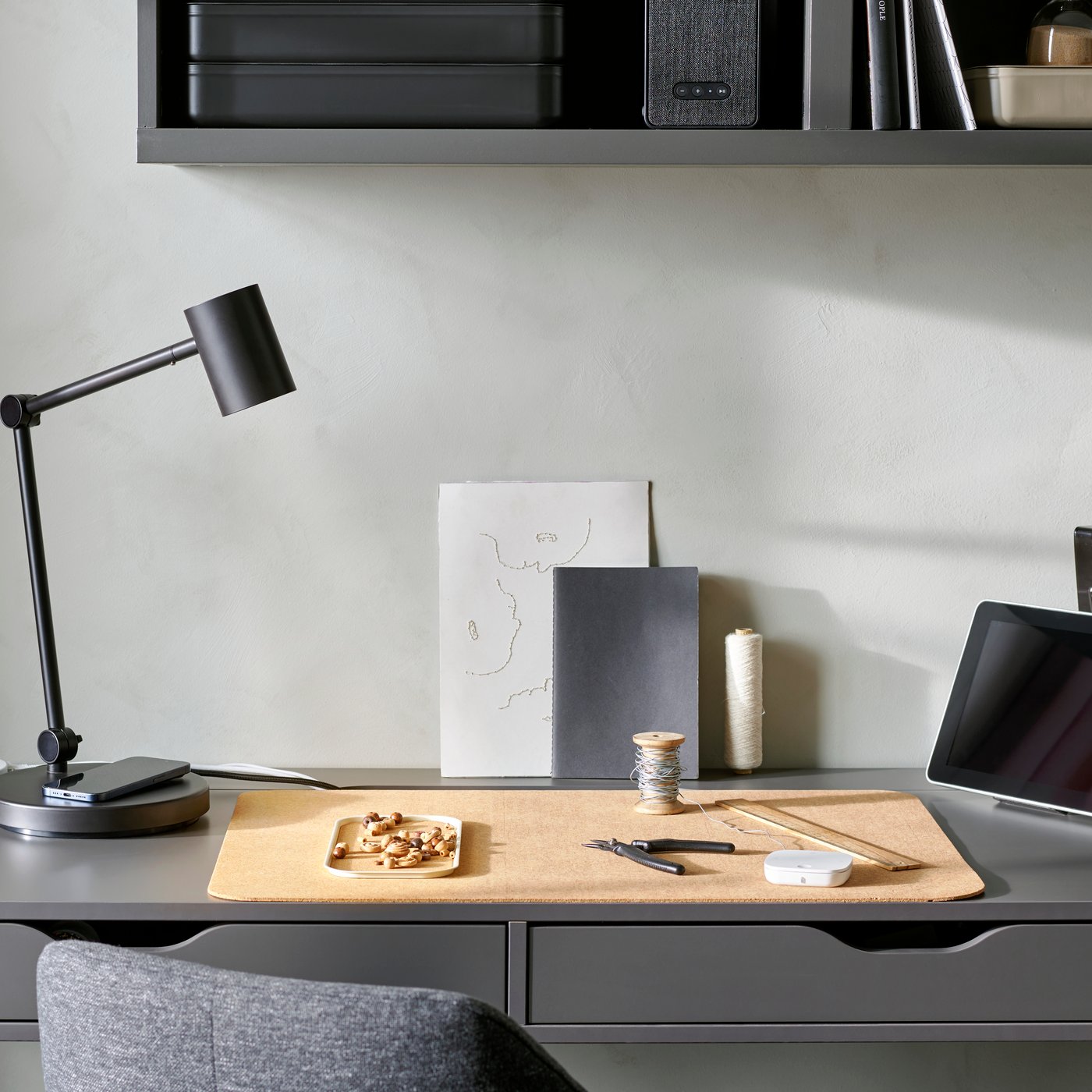 Vari prodotti home office smart su una scrivania ALEX grigia tra cui una lampada DIRIGERA.