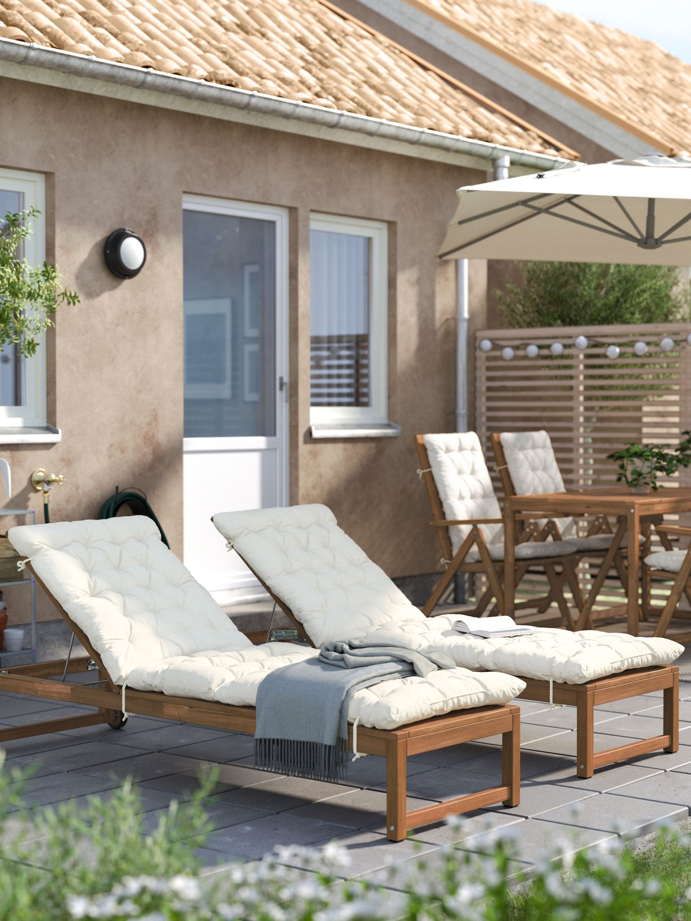 Un lettino prendisole NÄMMARÖ in mordente marrone chiaro con cuscino KUDDARNA beige, perfetto per rilassarti all’aperto.