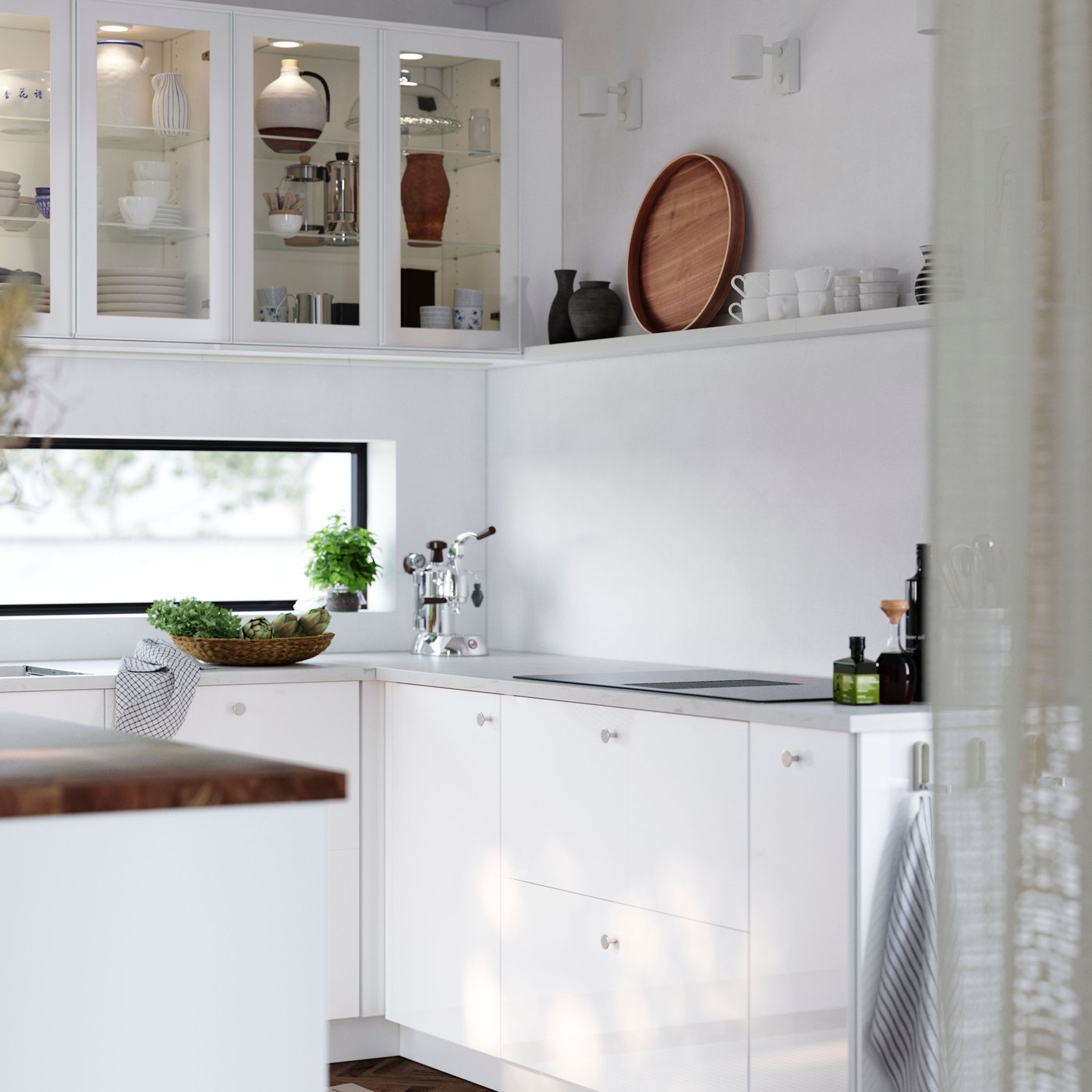 A light kitchen with a wooden floor has cabinets with glossy white RINGHULT fronts and wall cabinets with HEJSTA glass doors.