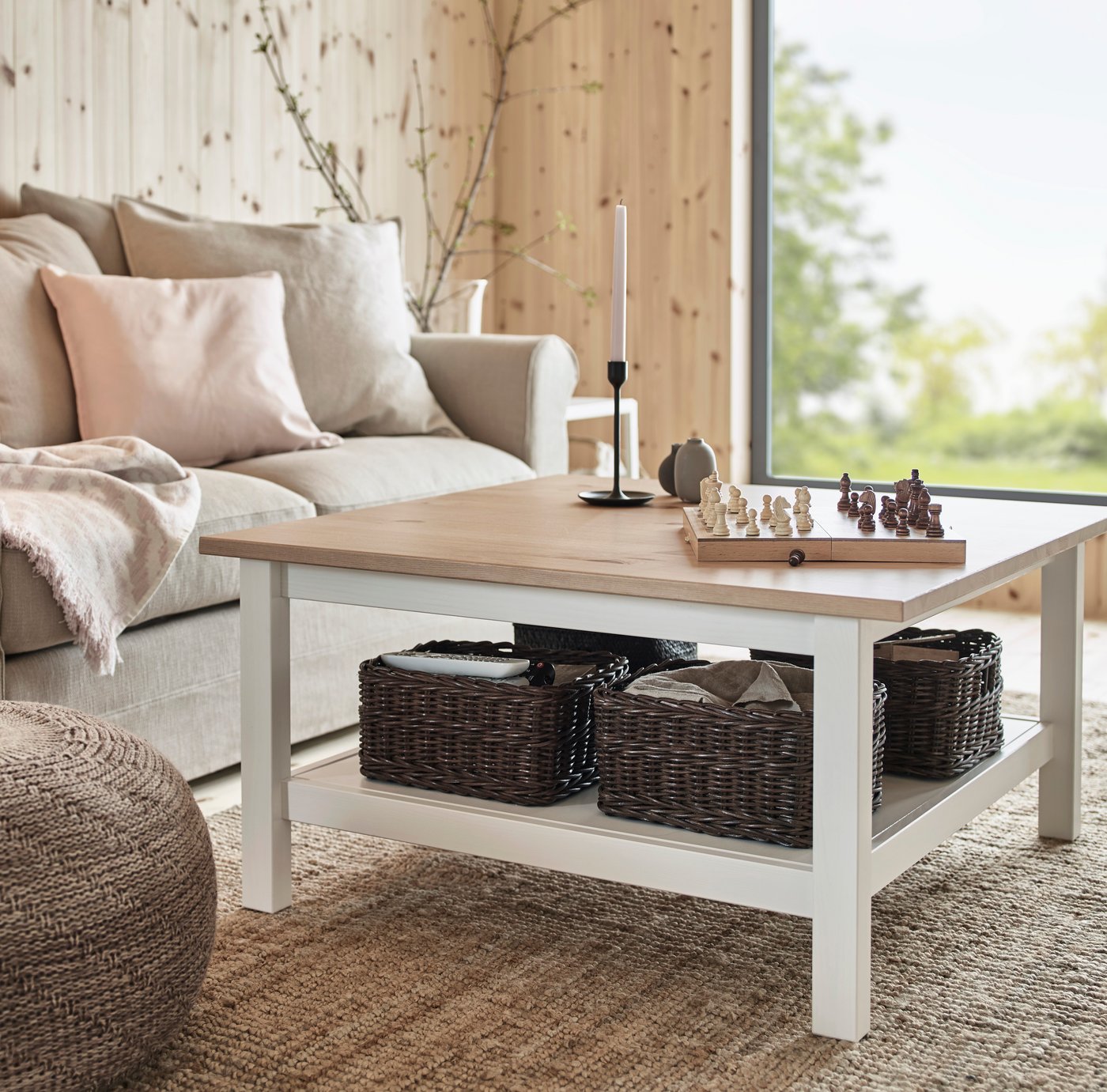 HEMNES coffee table in a bright living room with pine walls and a LOHALS rug.