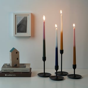 Four multicoloured ENGADINVIDE unscented chandelier candles in a black candle holder.