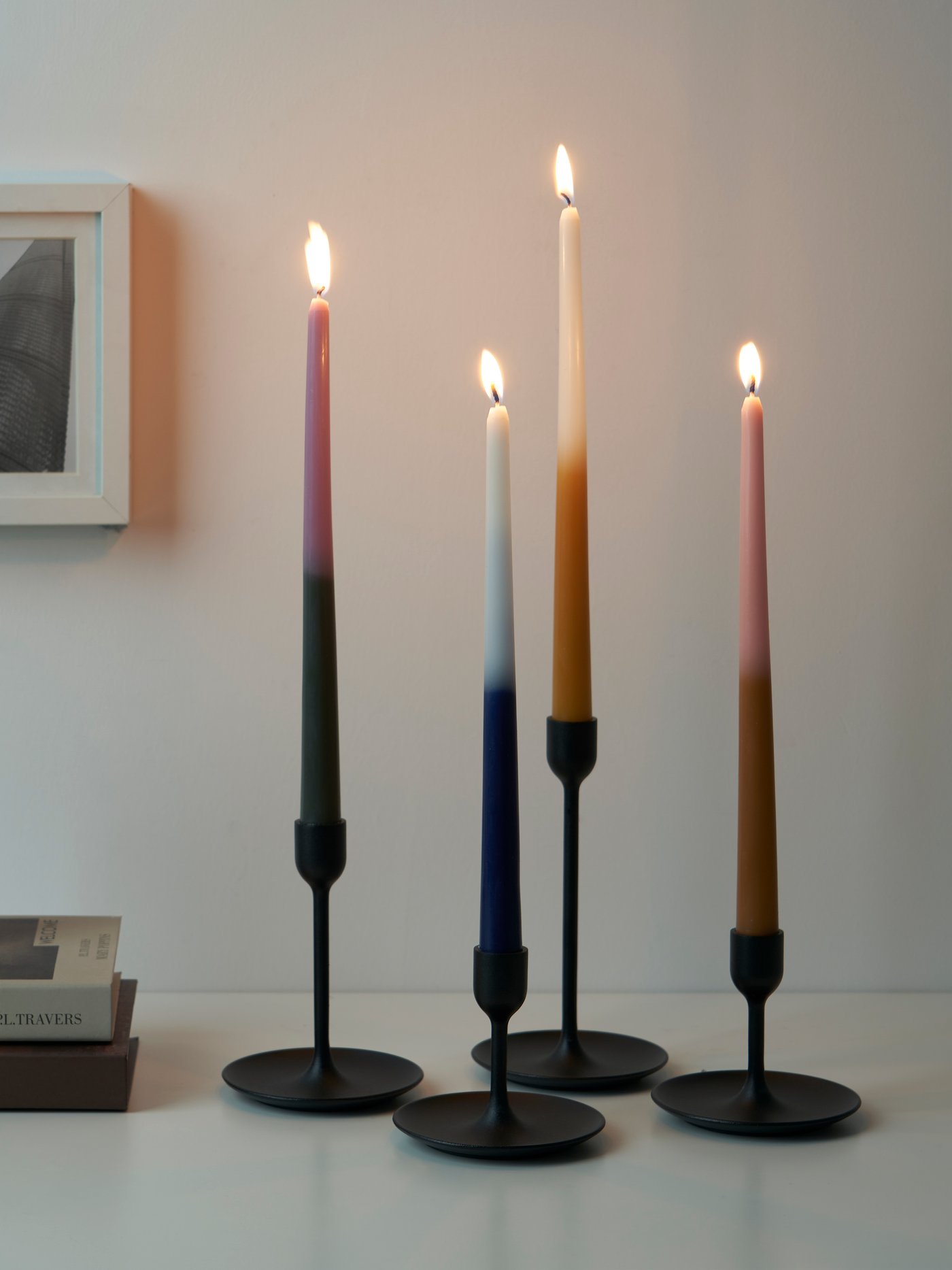 Four multicoloured ENGADINVIDE unscented chandelier candles in a black candle holder.