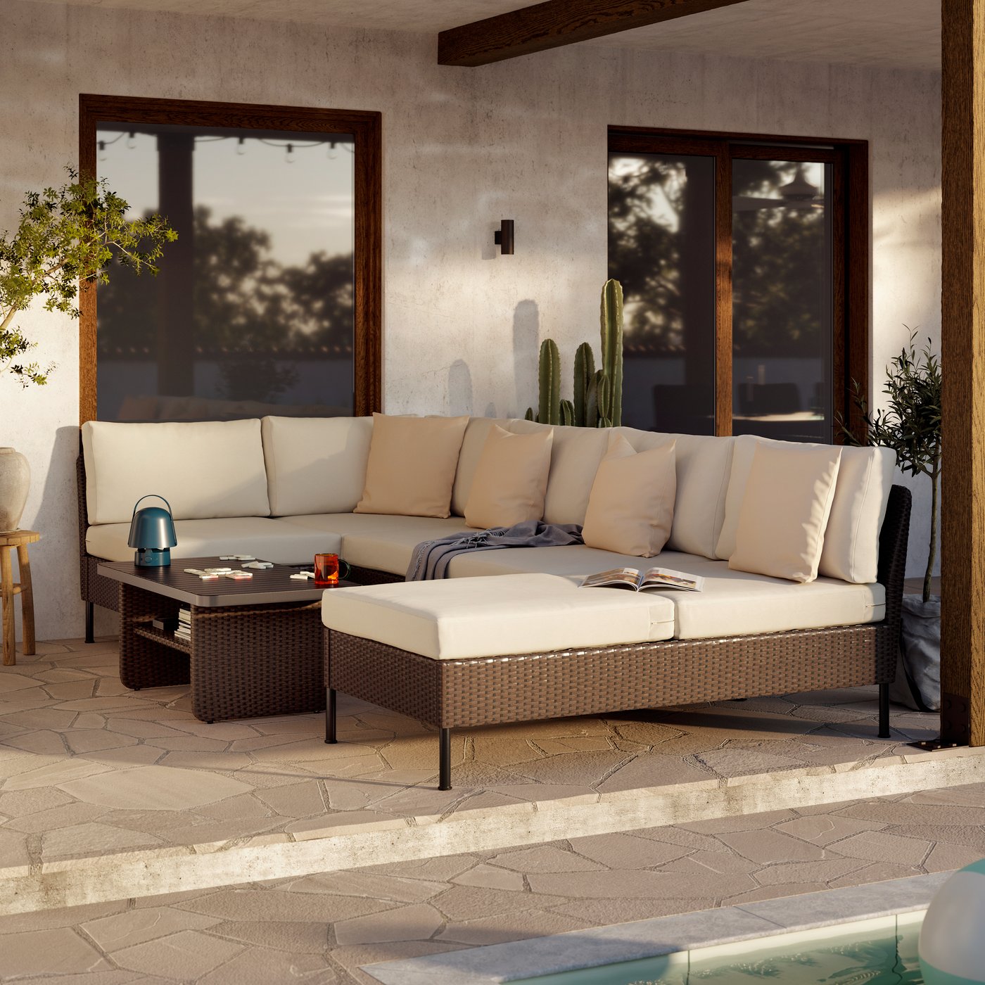 A generous outdoor lounge area with VITTSKÄR modular sofas and coffee table in dark grey. A large plant pot next to it.