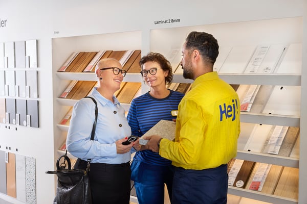An IKEA employee shows a worktop sample to a customer in an IKEA store.