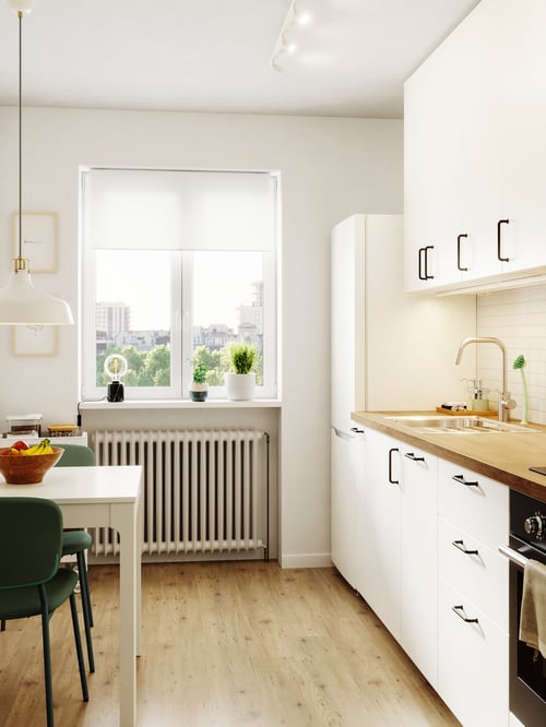 Kitchen with exterior lighting consisting of base cabinets, wall cabinets with MISTUDDEN doors, a high cabinet, and a table.