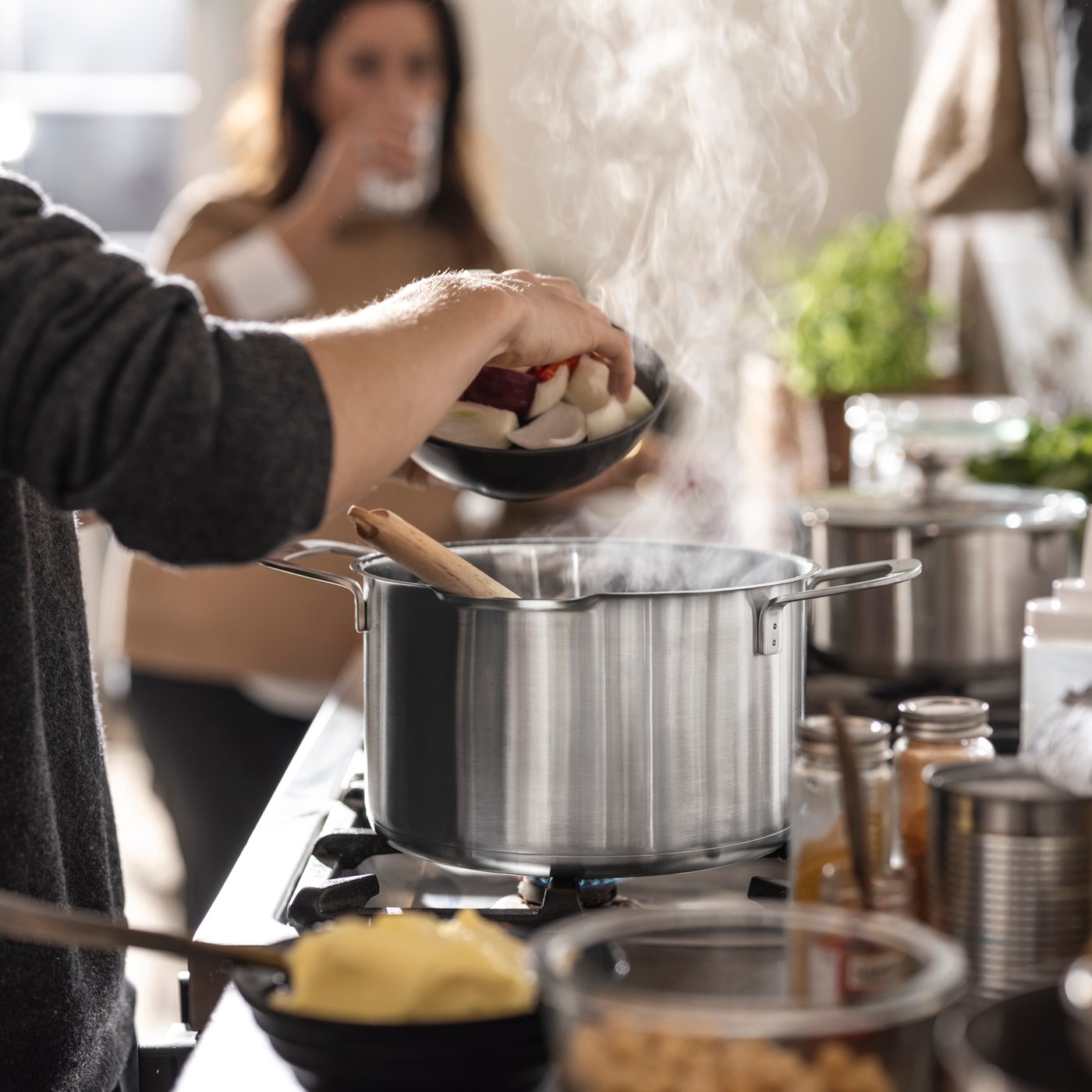 En HEMKOMST-gryte i rustfritt stål/glass med lokk.