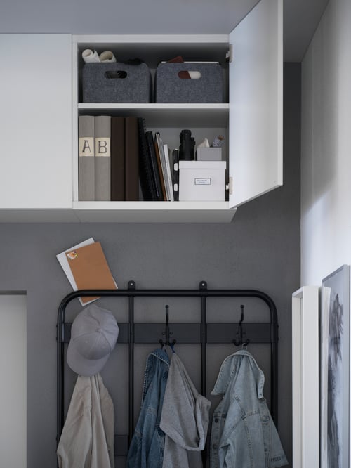 Un hol modern cu o unitate de raft cu o ușă deschisă cu două cutii dreptunghiulare în interior și un cuier.