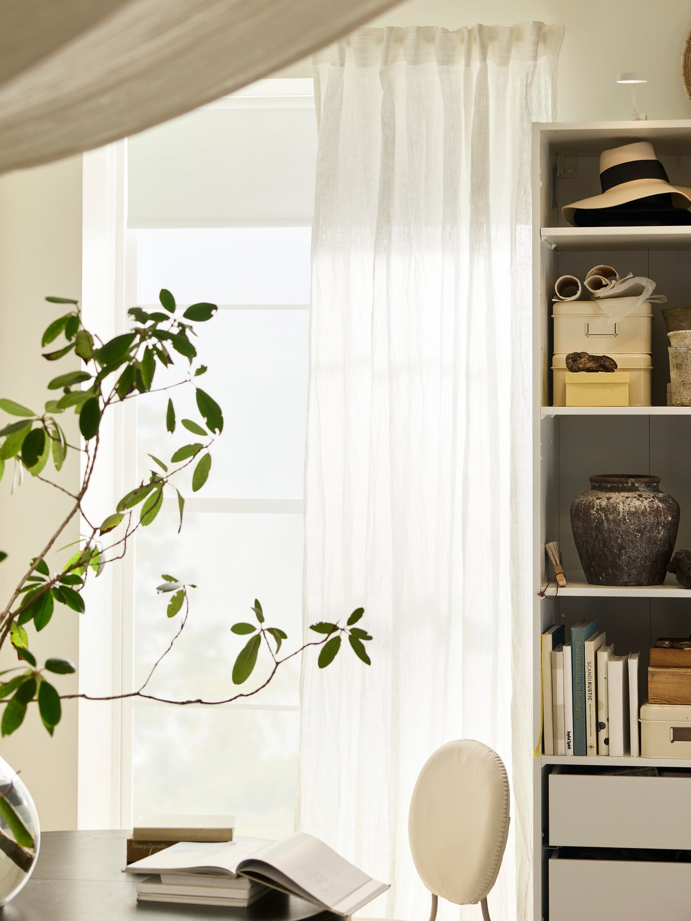 A pair of white DYTÅG curtains hang at a large window with a white FÖNSTERBLAD block-out blind, beside a white wardrobe.