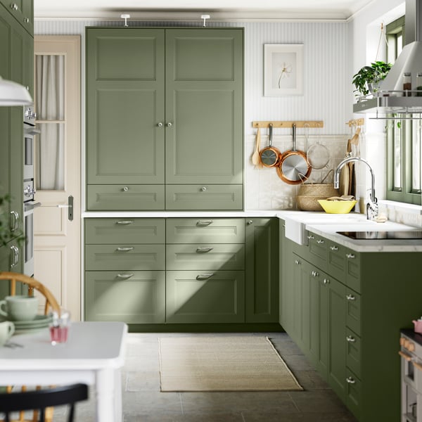 A grey-green AXSTAD L-shaped kitchen