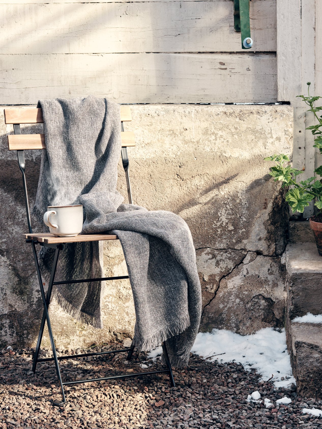 En stol står emot en vägg utomhus.
