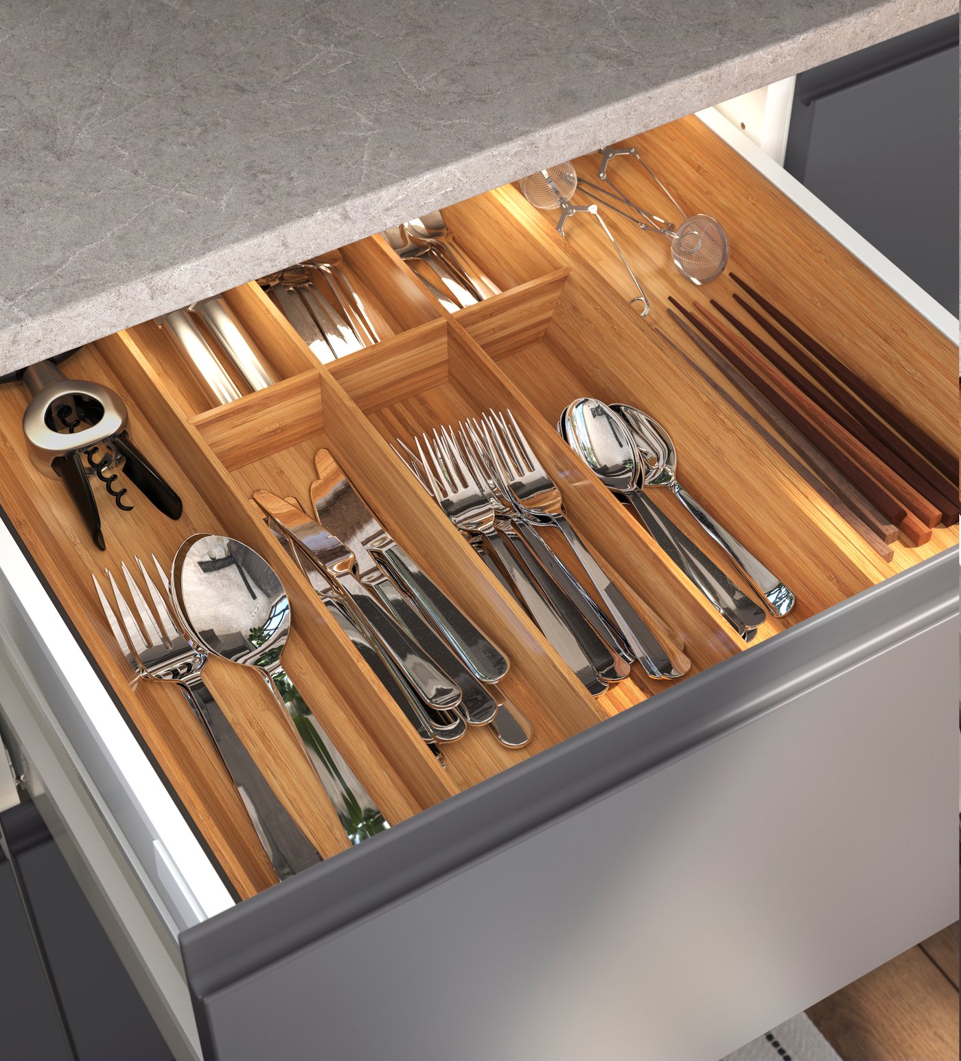 Un cassetto della cucina aperto con all'interno posate e altri accessori per la cucina