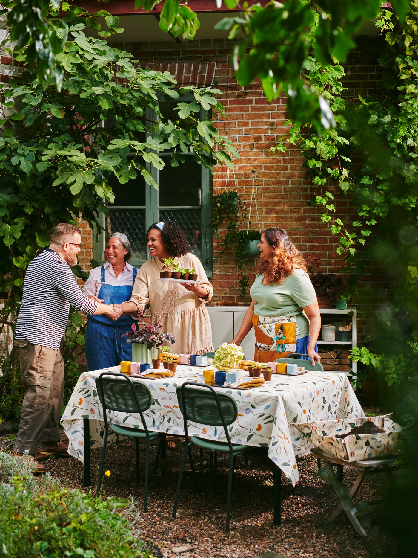 Quatre personnes en train de jardiner dans un jardin.