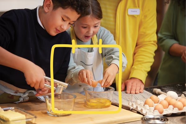 Two children baking in a kitchen.