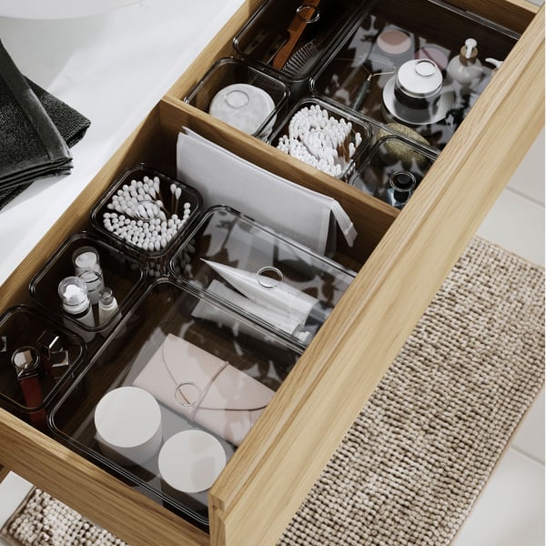 The ÄNGSJÖN wash-stand with drawer, filled with toiletries, cotton buds, towels, and skincare containers, organised neatly.