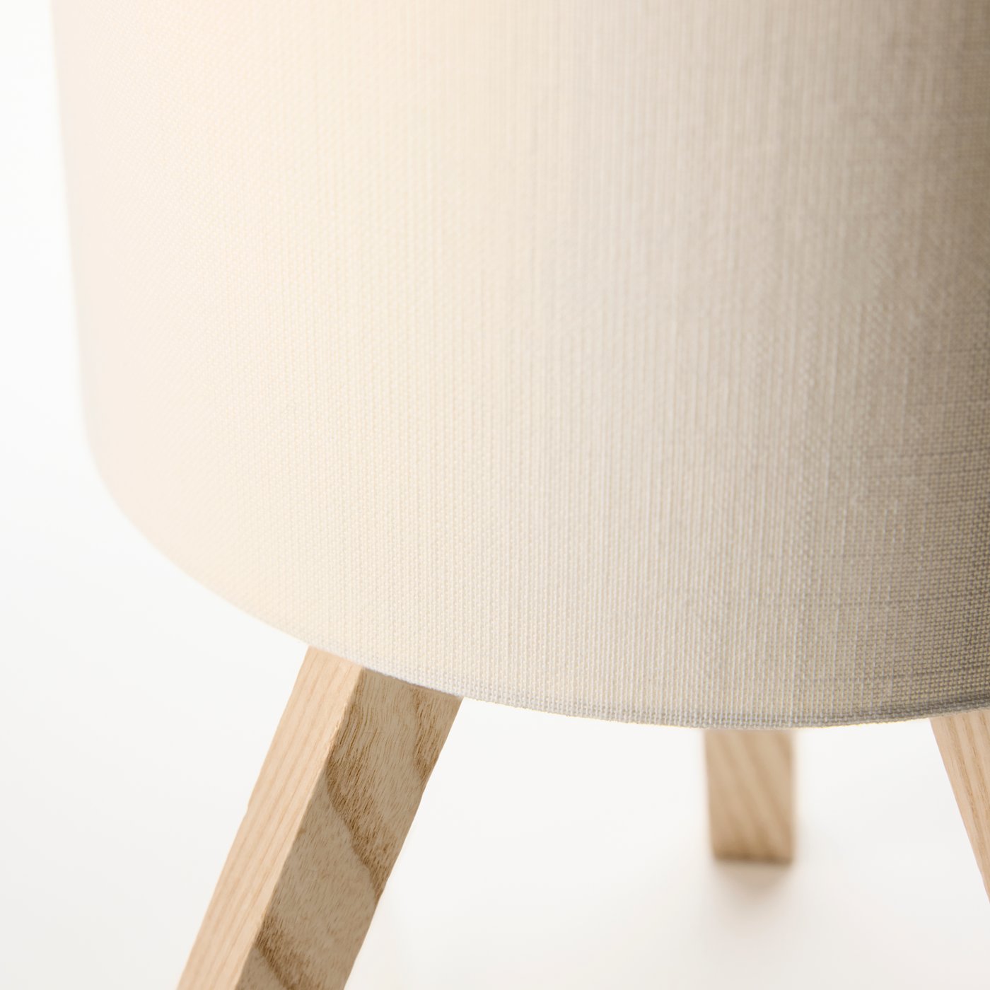 A close-up of a STORSEGEL table lamp, emphasising the textile texture of the shade and the ash wood of the foot.