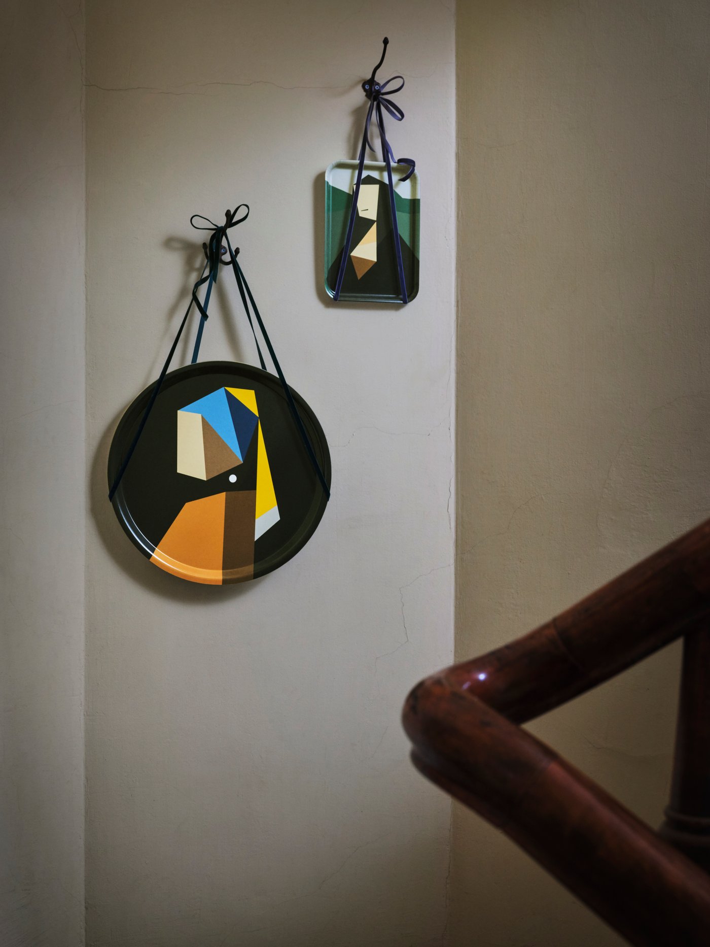 Bi DEKORERA erretilu, da Vinci eta Vermeer margolarien irudi moldatuekin, zintzilik daude bata bestearen ondoan soka batekin horma marroi argian.