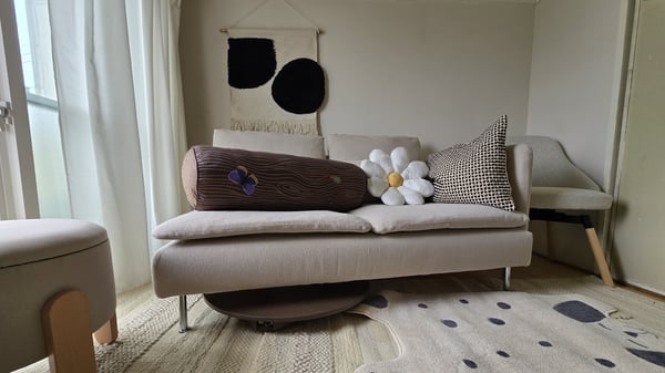 ベージュのソファー、スツール、ラグなど、落ち着きのあるリビング。