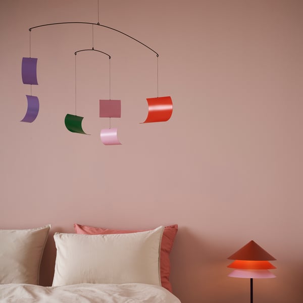 Una habitación con una lámpara de techo TESAMMANS sobre una cama. Al costado de la cama una lámpara sobre un velador.
